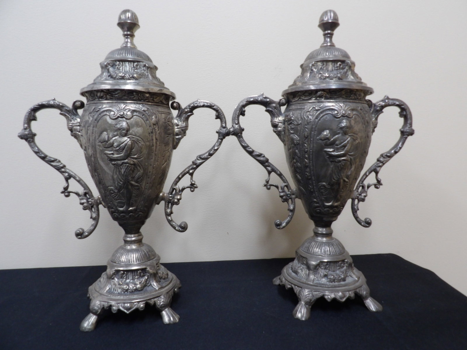 pair of ornate pewter lidded urn with figural relief decorations: 16.6 inches height.