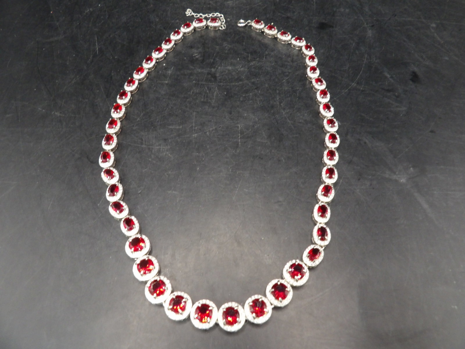 elegant simulated ruby tennis necklace with simulated ruby surrounded by CZ: 17.5 inches length plus one inch extender. We will inhouse ship items to you very affordable and efficient. Select self-arrange shipping.