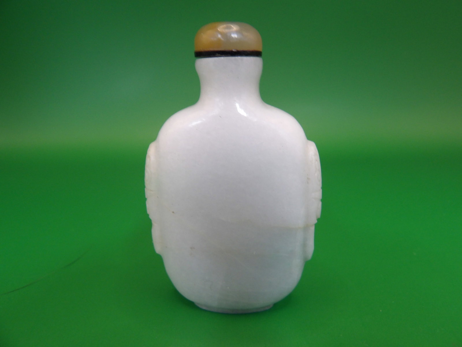 Chinese carved well hollowed jadeite jade snuff bottle with mask handles: 2.3 inches height.
