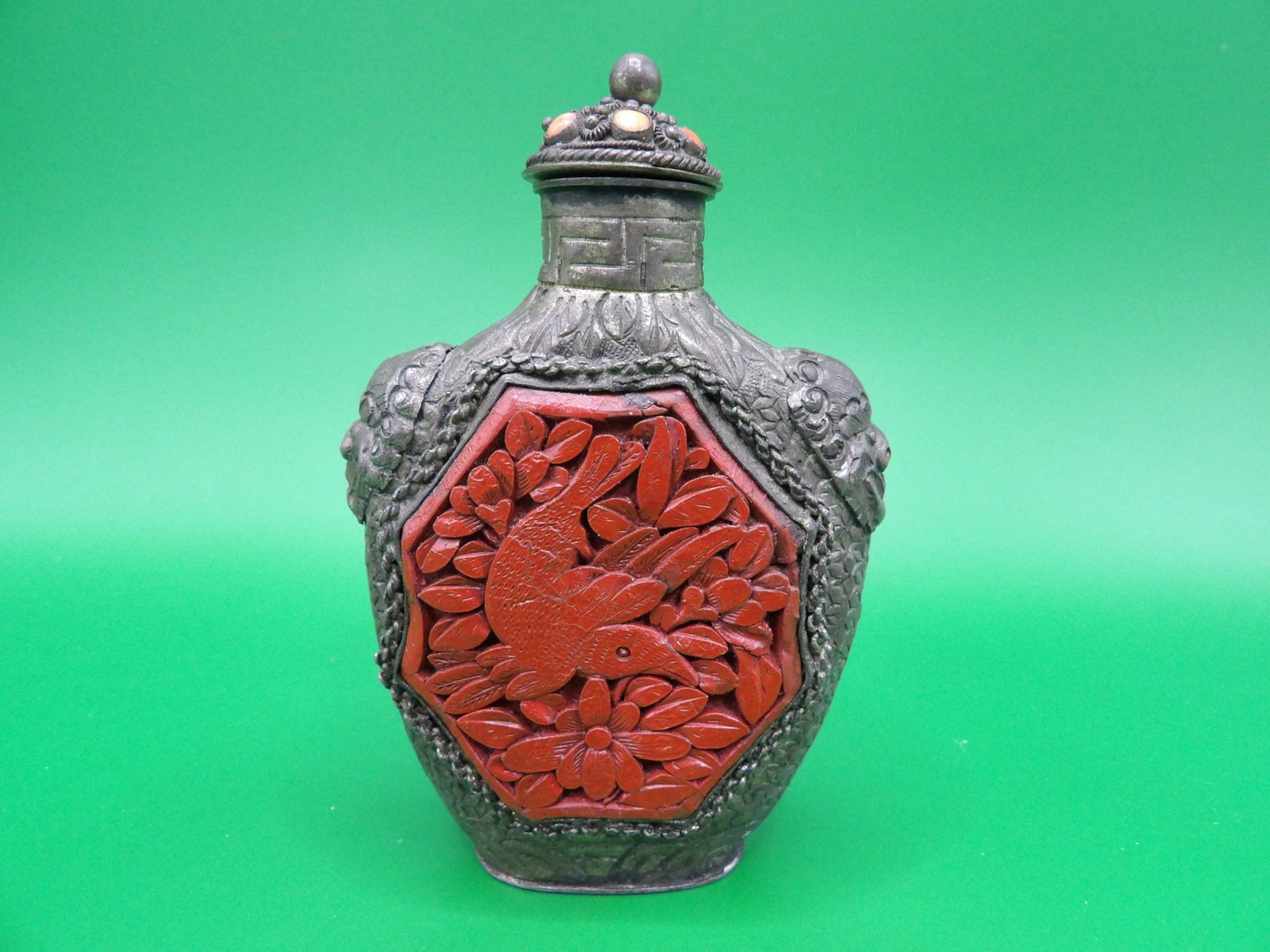 very fine cinnabar inlaid repousse metal snuff bottle with lion heads and mark on the bottom: 3.1 inches height.