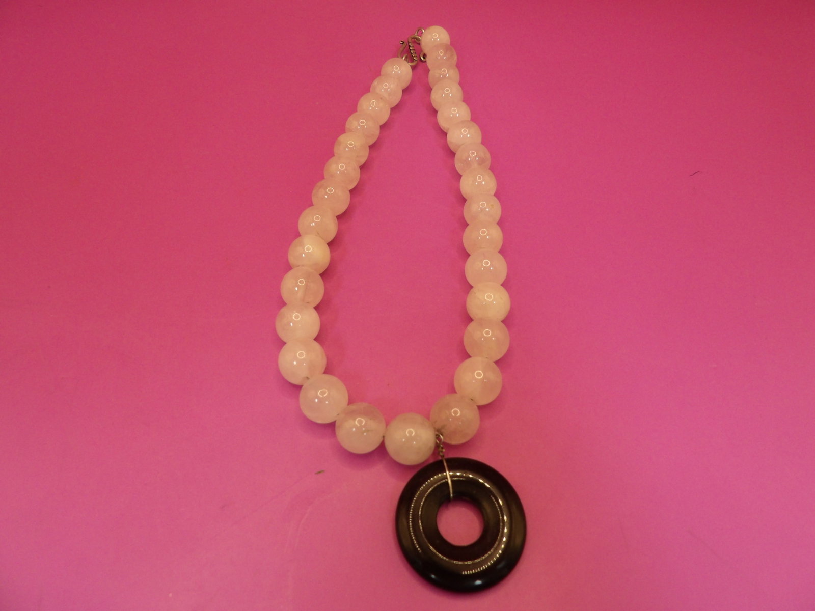 carved rose quartz beaded necklace with a black jade or obsidian pendant: 15 inches long necklace with 1 inch long pendant. 80 grams.