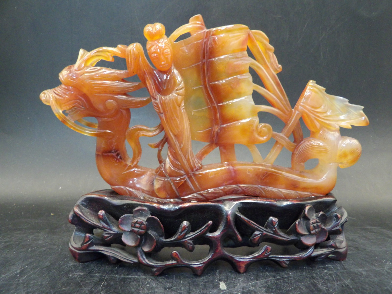 fine Chinese carved carnelian woman riding dragon boat sculpture with custom wood base: 5.5 inches length.