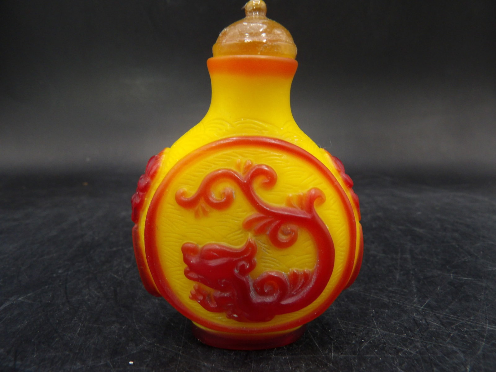 antique Chinese yellow peking glass snuff bottle with red overlay dragon and mask handles: 2.6 inches height.