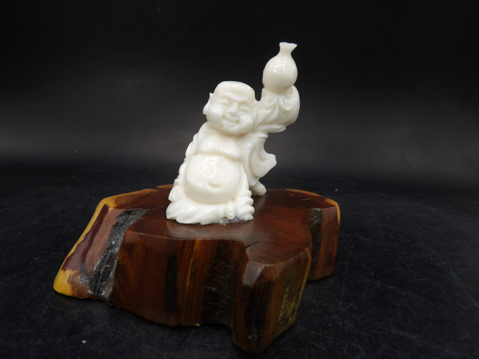 fine Chinese coral carved laughing buddha statue adhered to wood base: Over 3 inches height including natural wood base.