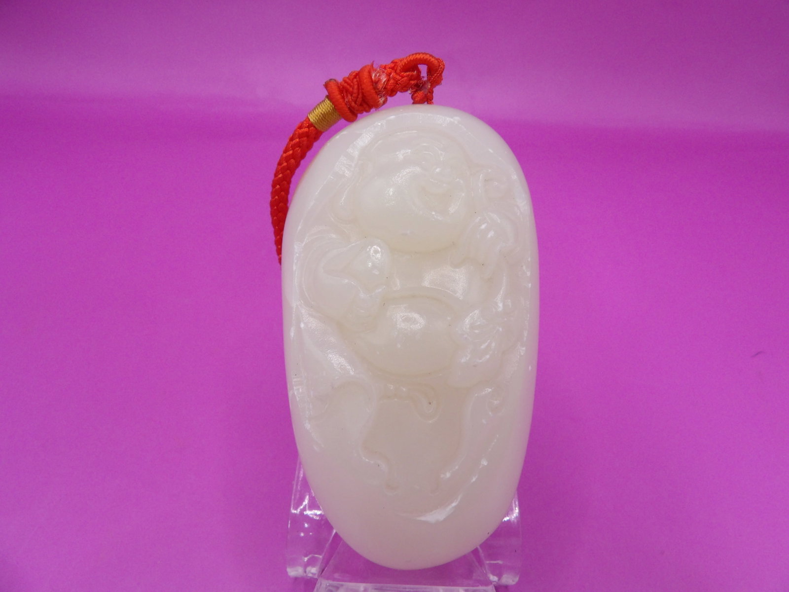 Chinese carved jade laughing buddha boulder with hand held red coral loop: 3 inches height. 172 grams.