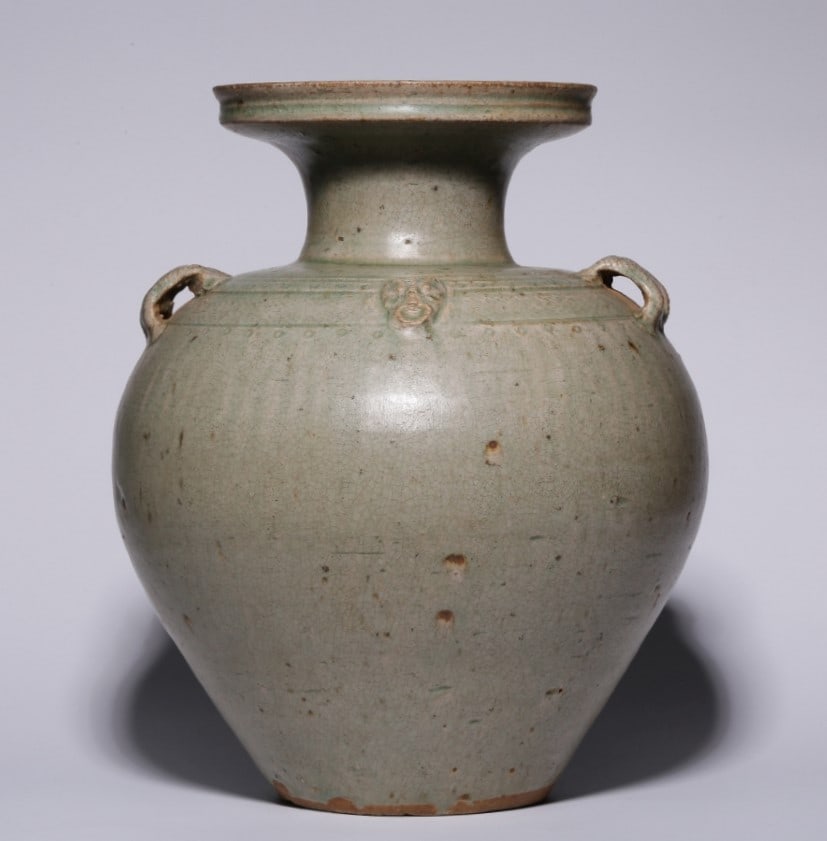 A piece of celadon ear vase from the Yue kiln of the Western Jin Dynasty: Western Jin Dynasty Yue kiln celadon ear bottle This bottle plate neck neck shoulder symmetrical ear drum belly gradually closed flat bottom. The glaze is blue-green, the tire is dense and hard, the g