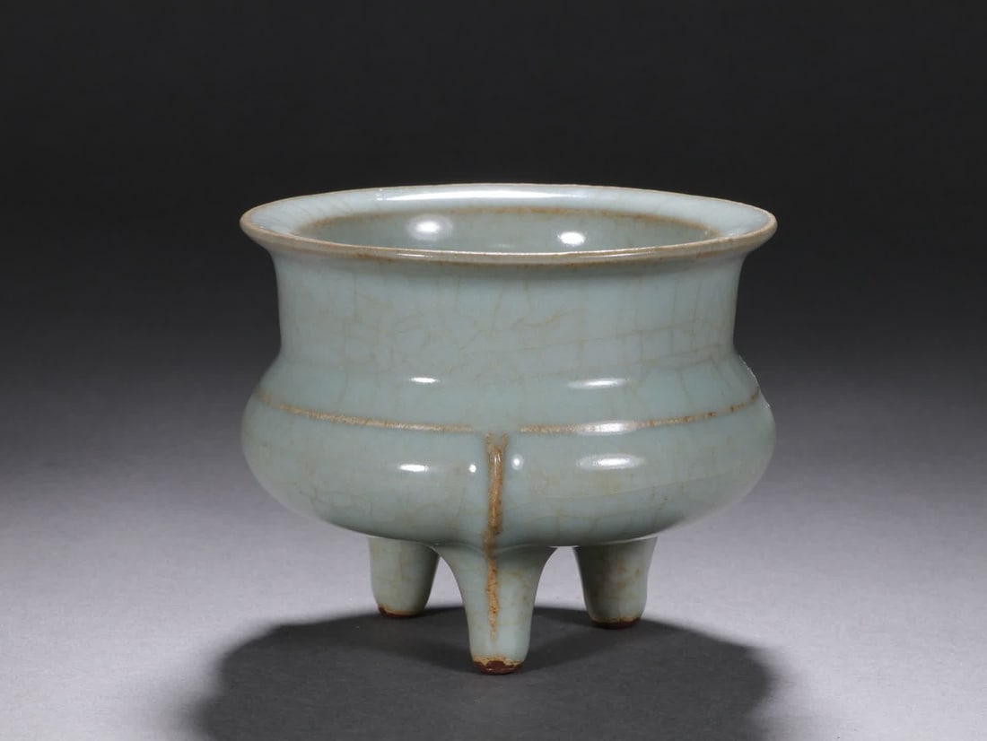 A Song Dynasty official kiln celadon three-legged furnace: The celadon three-legged furnace of the porcelain organ kiln has a natural glaze color and exquisite craftsmanship, which is typical of the official kiln of the Song Dynasty SIZE: H:8cm W:10cm (The Di