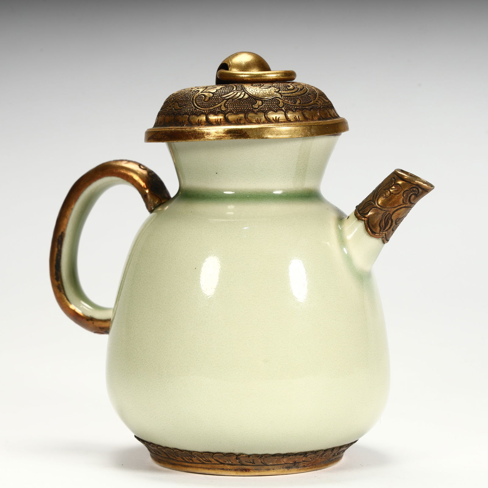 A Song Dynasty celadon gilt pot: The celadon porcelain pot body is rounded, the lid handle flows and the bottom foot is gilded, and the cover surface is engraved with phoenix patterns, and the craftsmanship is delicate SIZE: H:11.5cm