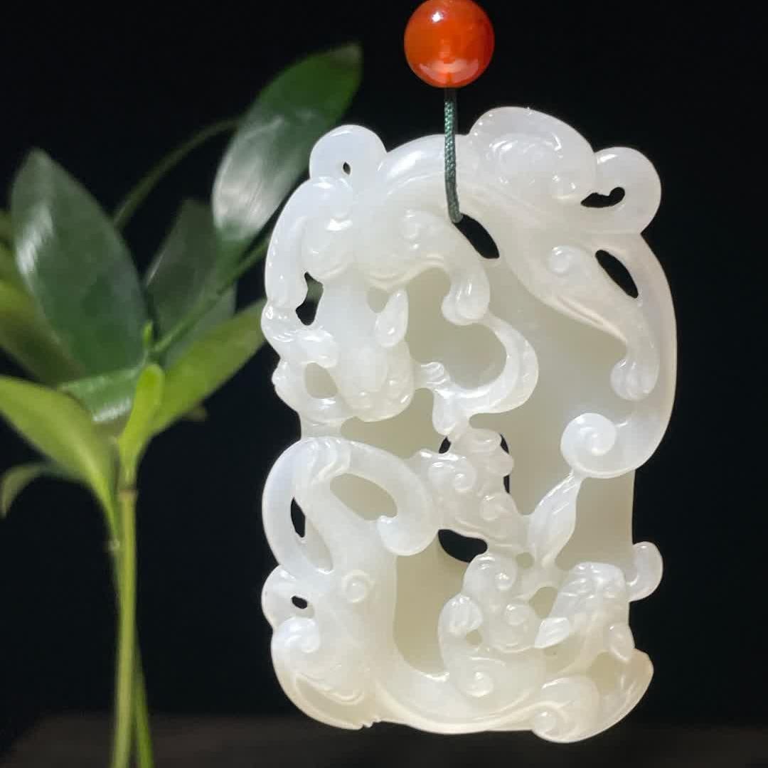 A jade pendant of the Qing Dynasty "Double Dragon Holding Ganoderma": The front is decorated with high-relief sculptures, the shape of the double dragon coiled around Ganoderma lucidum is curled and flexible, the details of the dragon's claws and mane are accurately