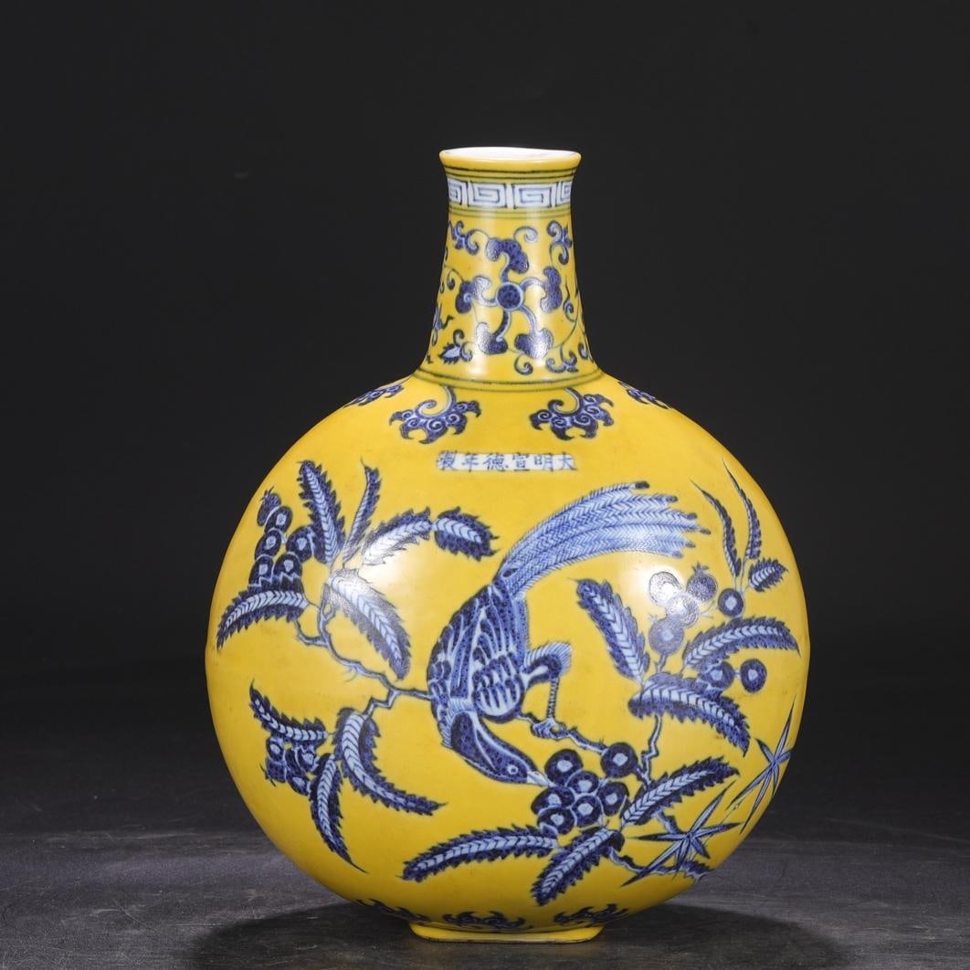 A large flat bottle with a yellow background blue and white folded branches and flowers and birds: The large flat bottle with yellow blue and white broken branches and flowers and birds in the Ming Dynasty Size:H:30.5cmCalibre5cmBellydiameter21.5cm (The Dimensions Of All Batches