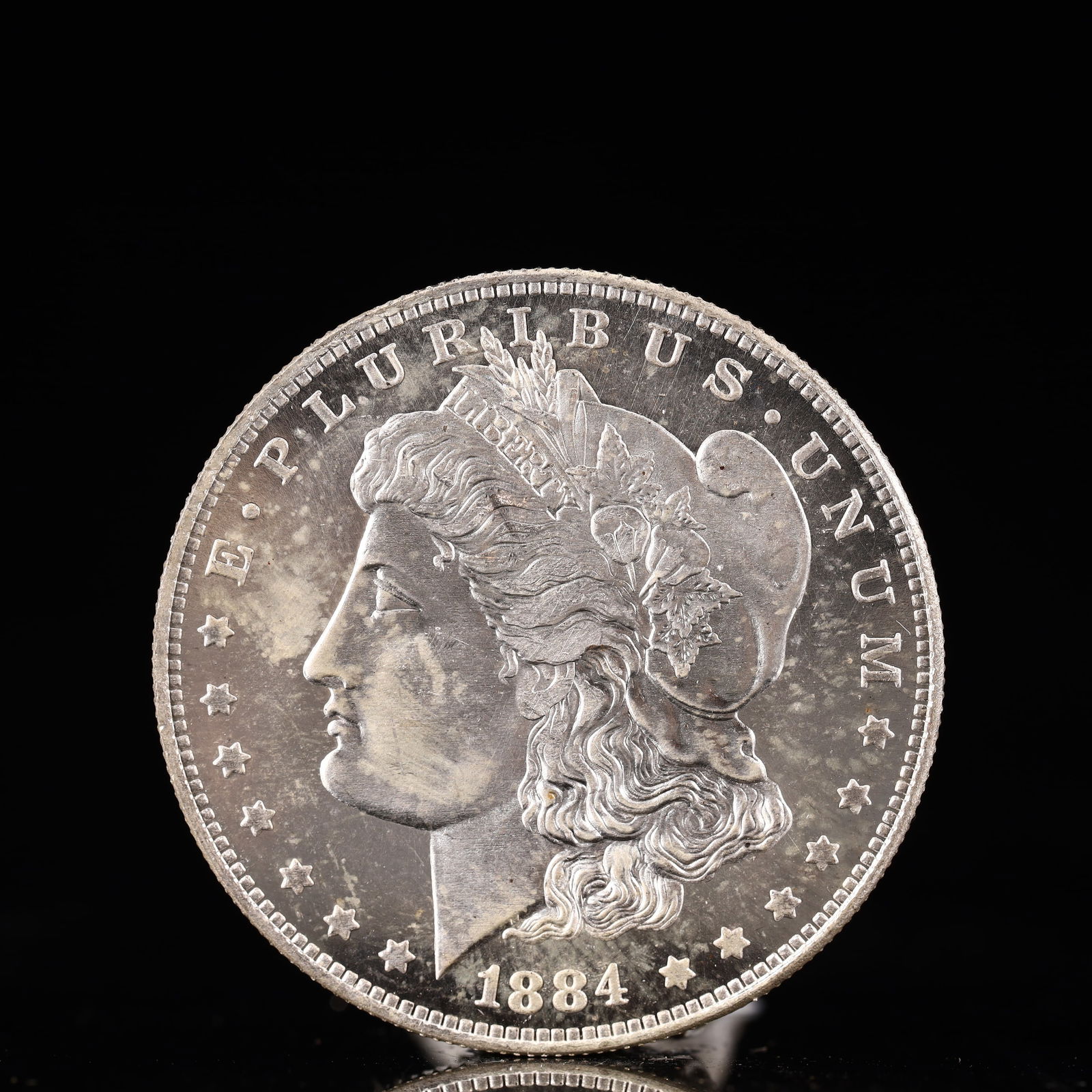 USA Morgan Dollar 1884 Coin: Obv: profile bust with date below and E PLURIBUS UNUM legend and stars around. Rev: eagle with In God we trust above within wreath with UNITED STATES OF AMERICA ONE DOLLAR legend. IN GOD WE TRUST /