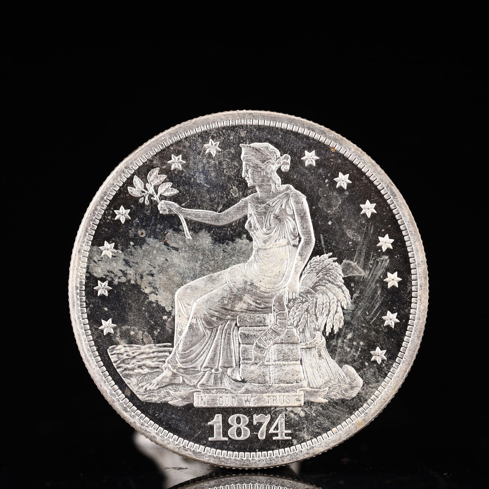 USA Trade Dollar 1874 Coin: American coin. Obverse: Liberty seated on a pedestal facing the sea to the left holding olive branches surrounded by 13 stars. IN GOD WE TRUST / LIBERTY / 1874. Reverse: An eagle holding branches