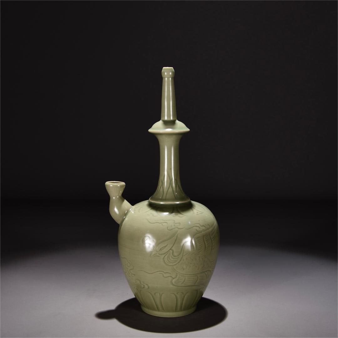 A secret color glaze carved phoenix pattern clean bottle of the Yue kiln in the Song Dynasty: The secret color glaze of the Yue kiln in the Song Dynasty is engraved with phoenix pattern clean bottles Size:H:37cm W:18cm (The Dimensions Of All Batches Are Manually Measured.If