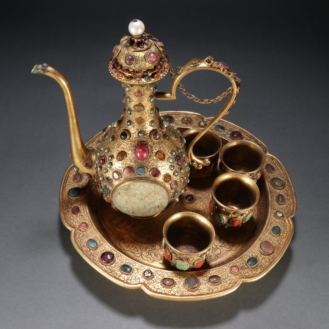 A set of copper gilt inlaid treasure wine utensils of the Qing Dynasty: Qing Dynasty copper gilt inlaid with treasure wine utensils size:kettleH:23.5cmW:18.7cmW:782.6gcupH:5cmW:5.3cmsingleW:116.4g (The Dimensions Of All Batches Are Manually Measured.If