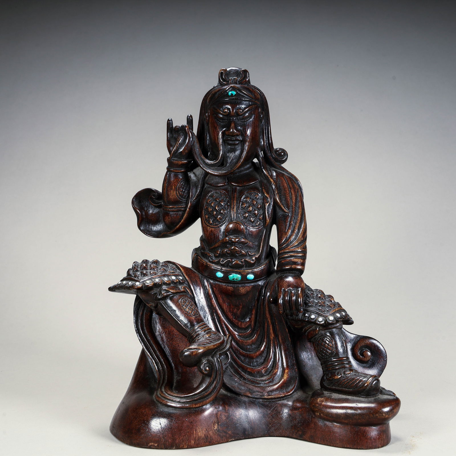 A seated statue of Guan Gong inlaid with agarwood inlaid in Qing Dynasty: The seated statue of Guan Gong in agarwood inlaid with turquoise in the Qing Dynasty Size: L: 24cm W:19cm H:14cm W:552g (The Dimensions Of All Batches Are Manually Measured.If You Need More Detailed I