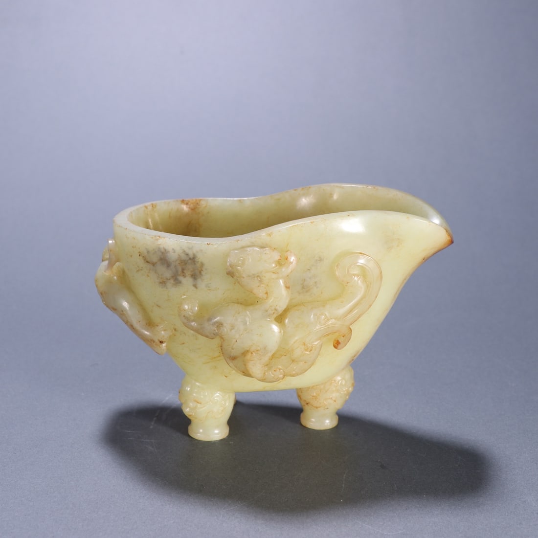 A Ming Dynasty Hetian topaz carved dragon three-legged cup: Ming Dynasty Hetian topaz carved dragon three-legged cup Sixe:H:8.1cm W:12cm W:364g (The Dimensions Of All Batches Are Manually Measured.If You Need More Detailed Information,