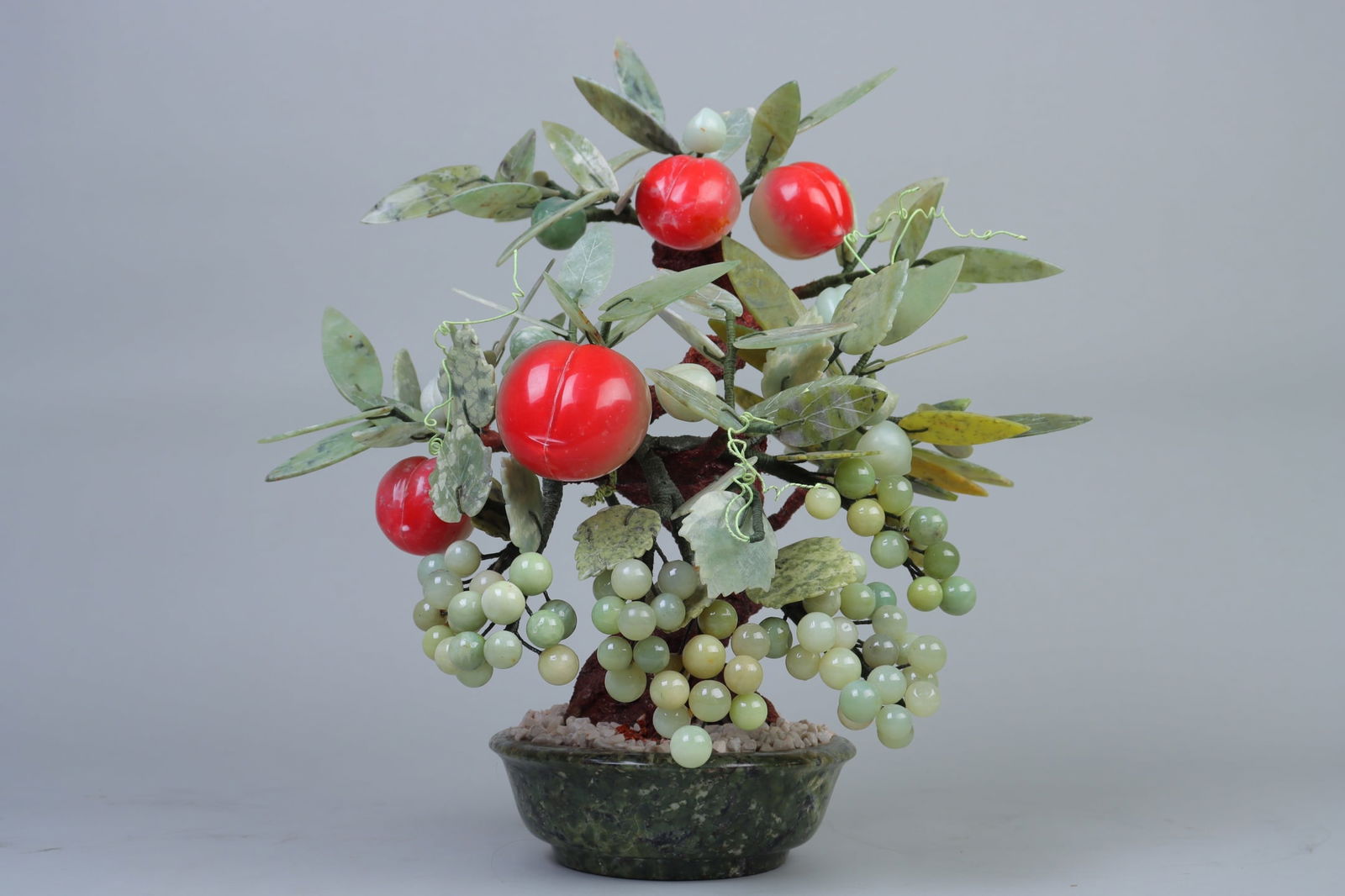 An Exquisite Serpentine Jade Flower and Fruit Pattern Bonsai: An Exquisite Serpentine Jade Flower and Fruit Pattern Bonsai Qing Dynasty, China Size:40cm (The Dimensions Of All Batches Are Manually Measured.If You Need More Detailed Information, Please Contact