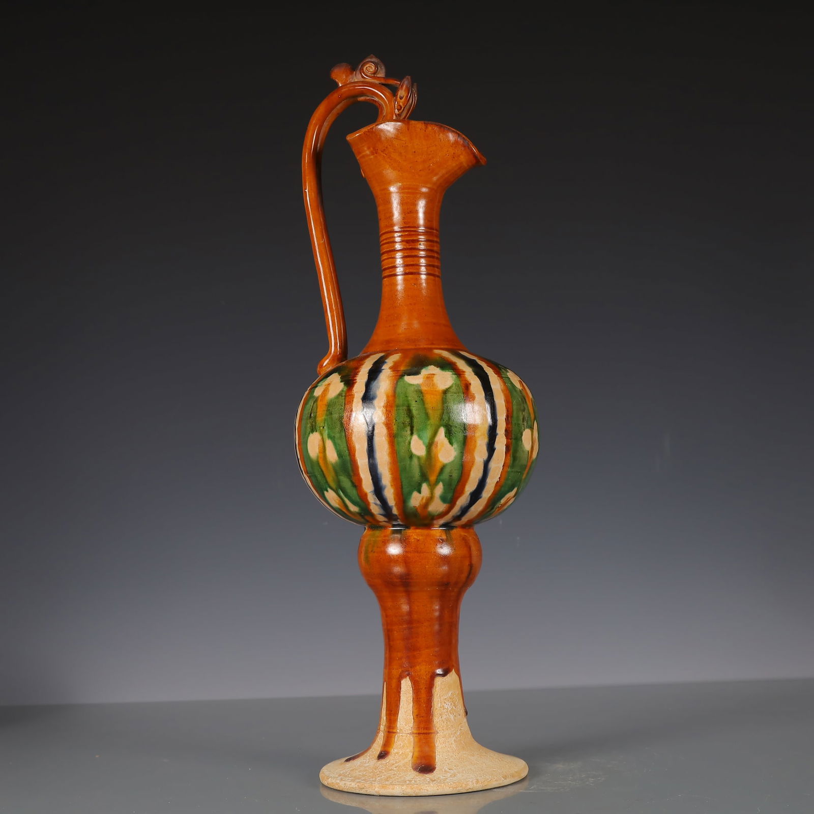 A Exquisite Trio-colored glazed pottery of the Tang Dynasty Dragon Pattern Ewer: A Exquisite Trio-colored glazed pottery of the Tang Dynasty Dragon Pattern Ewer Tang Dynasty, China Size:16cmx16cmx44cm Weight:1850g (The Dimensions Of All Batches Are Manually Measured.If You Need