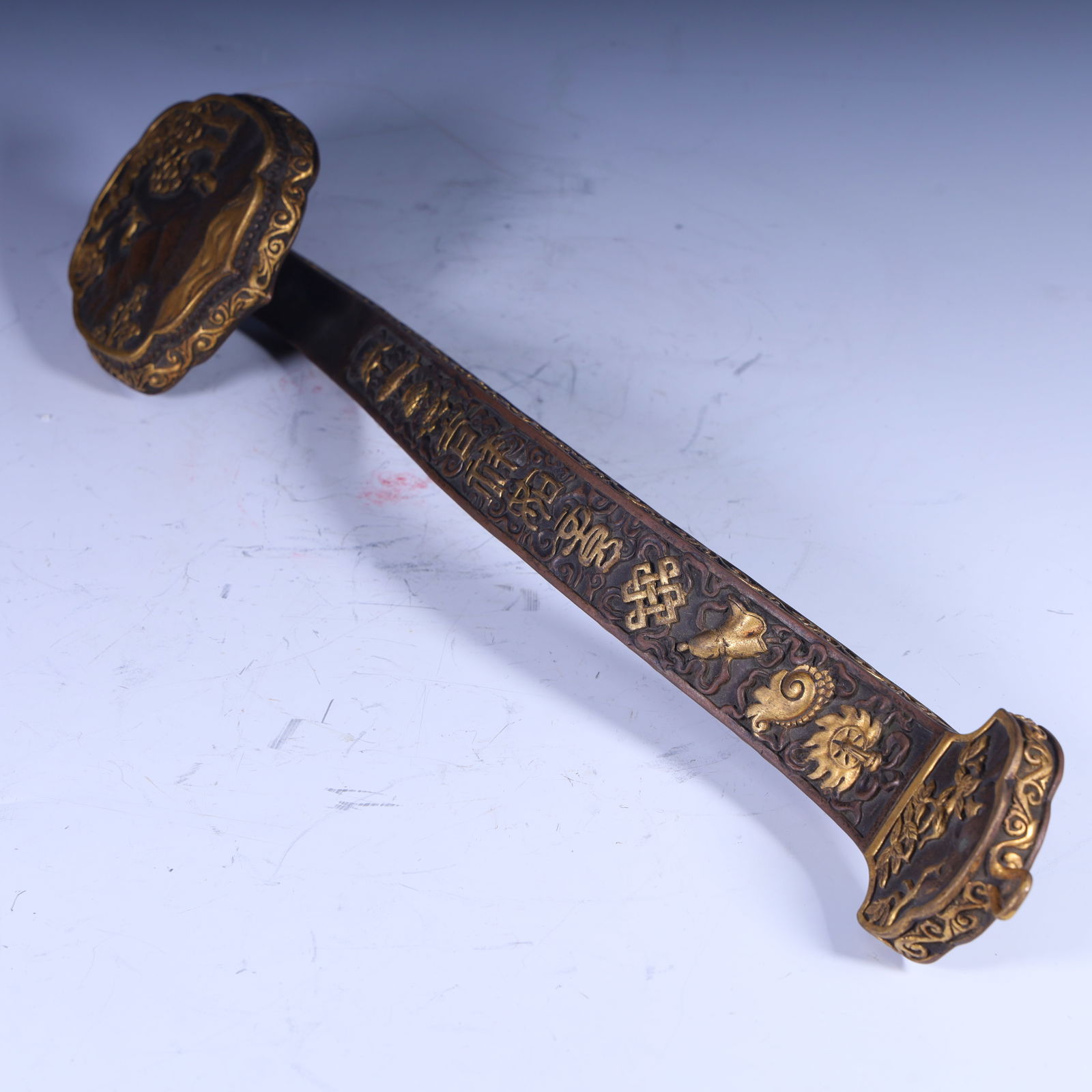 A copper gilt engraved Buddhist eight treasure ruyi from the Qing Dynasty: The copper gilt of the Qing Dynasty is engraved with the Buddhist Eight Treasures Size: H:5.5cm L: 40cm W:9.5cm W:1.2kg (The Dimensions Of All Batches Are Manually Measured.If You