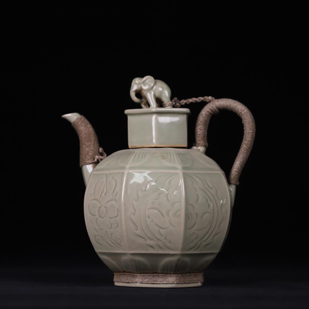 A celadon carved elephant button from the Yaozhou kiln in the Song Dynasty holds a pot in all: The celadon carved elephant button of the Yaozhou kiln in the Song Dynasty holds the pot in all directions Size:H:22cm (The Dimensions Of All Batches Are Manually Measured.If You
