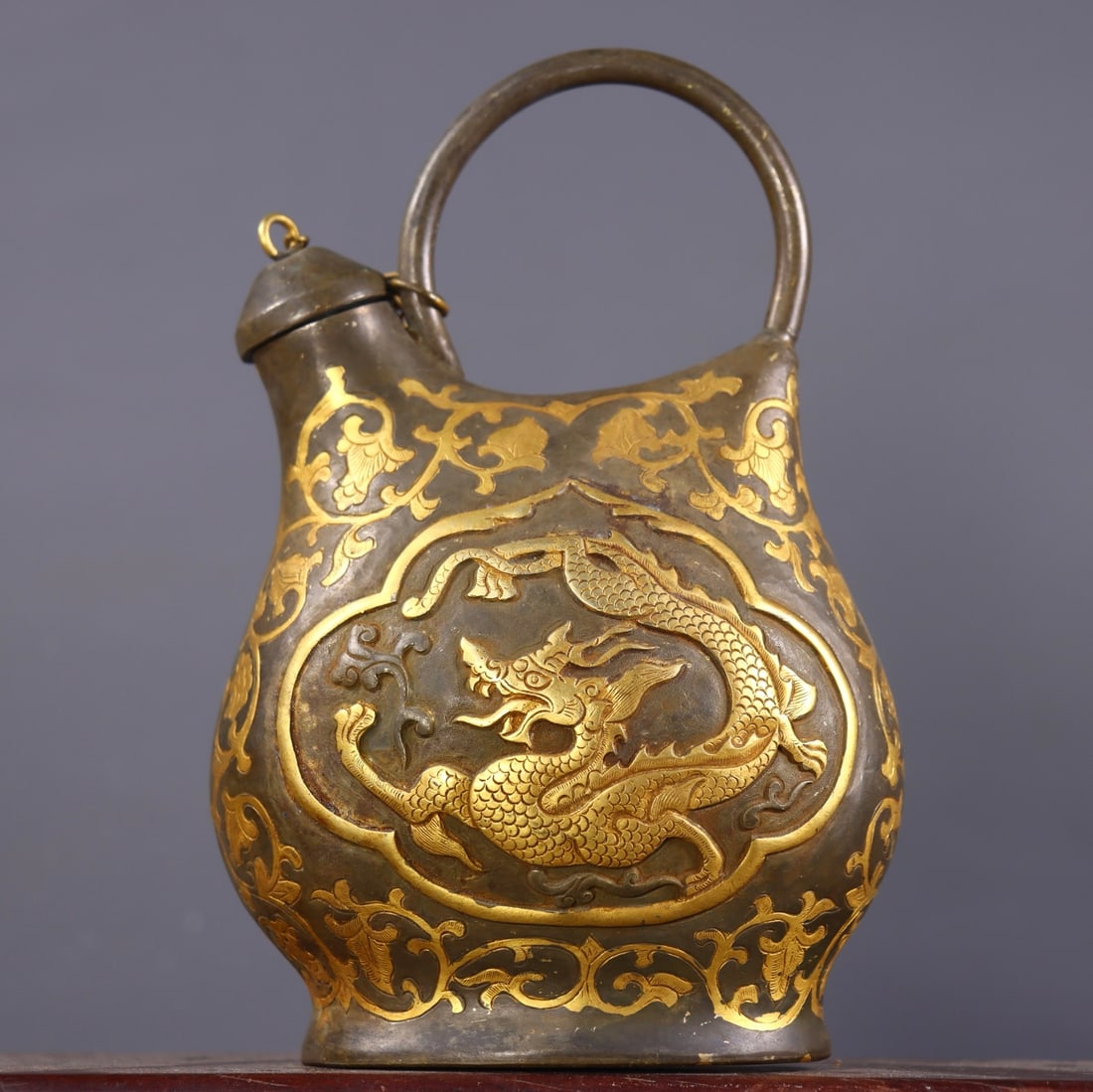 An Exquisite Gilt Bronze Lotus Pattern Dragon Pattern Ewer: An Exquisite Gilt Bronze Lotus Pattern Dragon Pattern Ewer Tang Dynasty, China Zhenguan Four-character Mark Size:17cmx10.5cmx7.5cm Weight:480g (The Dimensions Of All Batches Are Manually