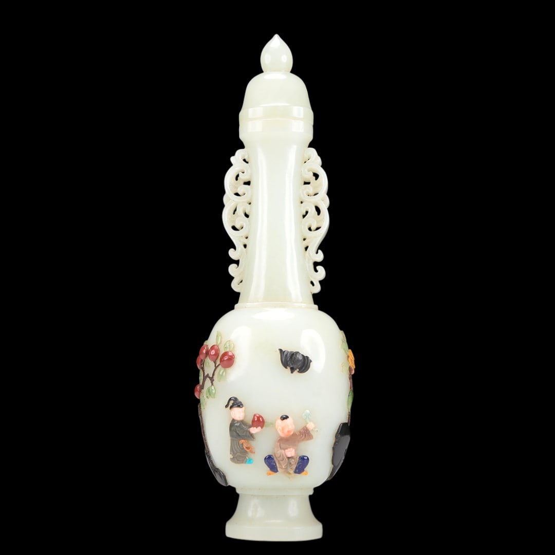 A Superb White Jade Gem-Inlaid 'Figure' Vase And Cover: A Superb White Jade Gem-Inlaid 'Figure' Vase And Cover. Of a tall, slender shape, supported on a subtly splayed foot, body inlaid in polychrome with fruits, bats and robed figures, topknot surmounted