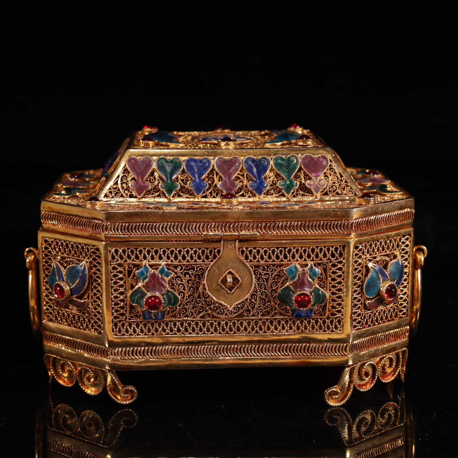 A piece of gold, using silk and blue technology, inlaid with rubies, the lid box is regular in: Gold, using silk, blue burning process, inlaid rubies, regular shape of the lid box, exquisite decoration, is the Qing Dynasty court or aristocratic jewelry storage utensils, reflecting the integratio