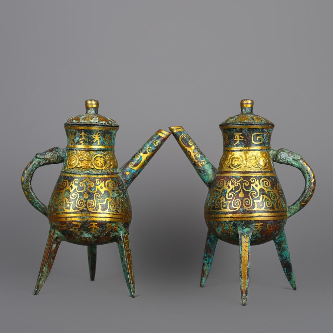 A pair of Han Dynasty bronze Cuojin three-legged wine jugs: Han Dynasty bronze Cuojin three-legged wine pot pair SIZE: Total W: 1090g Single L: 14cm W: 8.5cm H: 18.5cm (The Dimensions Of All Batches Are Manually Measured.If You Need More Detailed