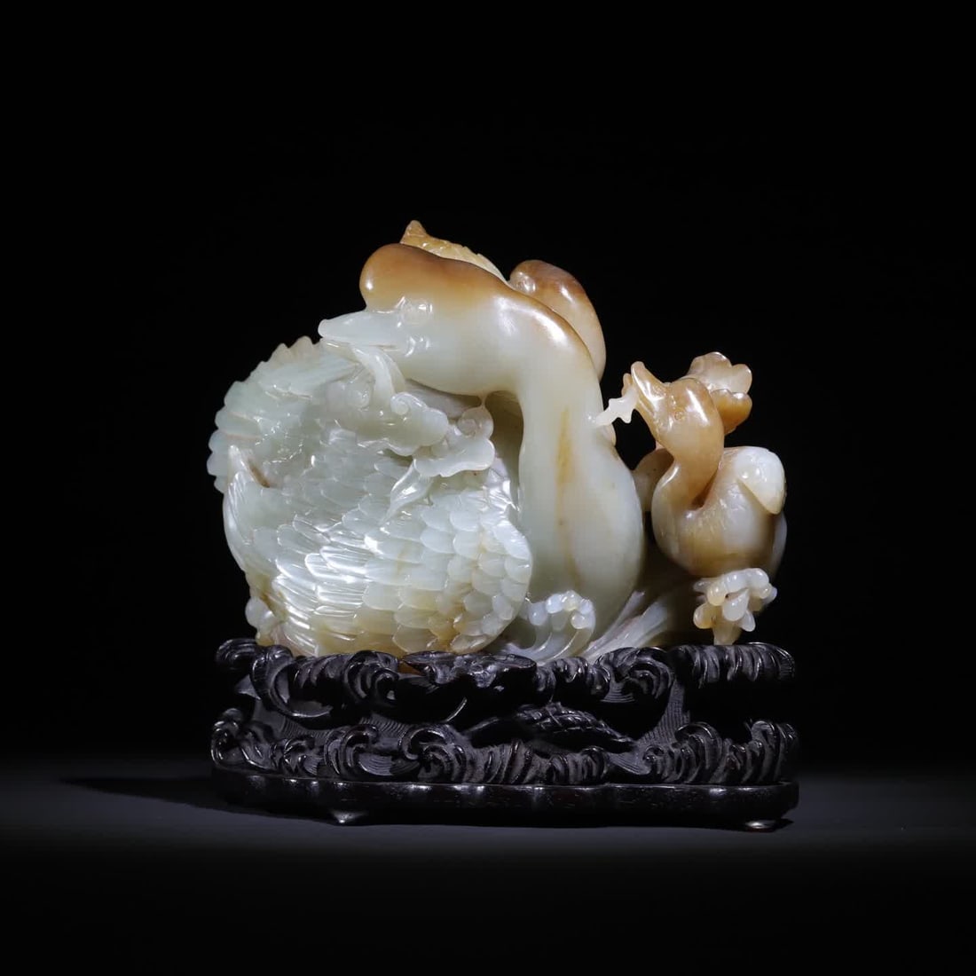 A piece of Qing Dynasty Hetian jade carving mother and child goose holding Ganoderma lucidum: The ornament is made of warm and greasy Hetian material, cleverly carved with natural colors, integrating the luster of jade and the mellowness of the skin color, using the techniques of round carving