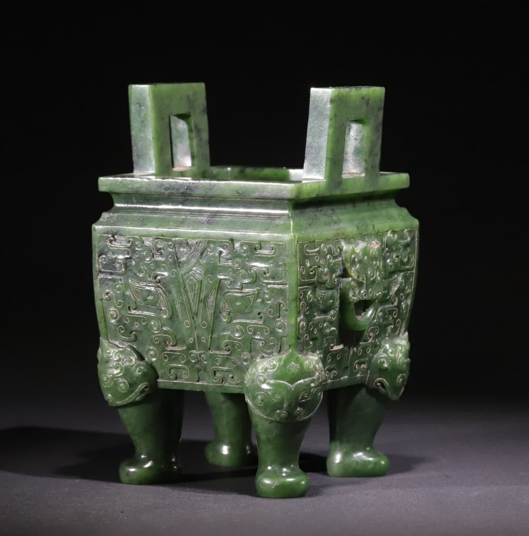 A Qing Dynasty Hetian jade beast face pattern jasper square tripod: This tripod is carved from a whole piece of deep jasper, the jade is thick green and even, the luster is restrained, and the local area has natural ink spots and light-colored jade texture, which adds