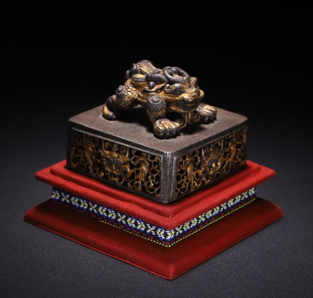 A Qing Dynasty iron-cut gold hollow auspicious beast button stick bazaar seal: Qing Dynasty iron-cut gold hollow auspicious beast button Zhi Bazaar seal This seal is made of iron, the whole body is hollow carved, and decorated with the "iron cut gold" craft seal button of Hua kn