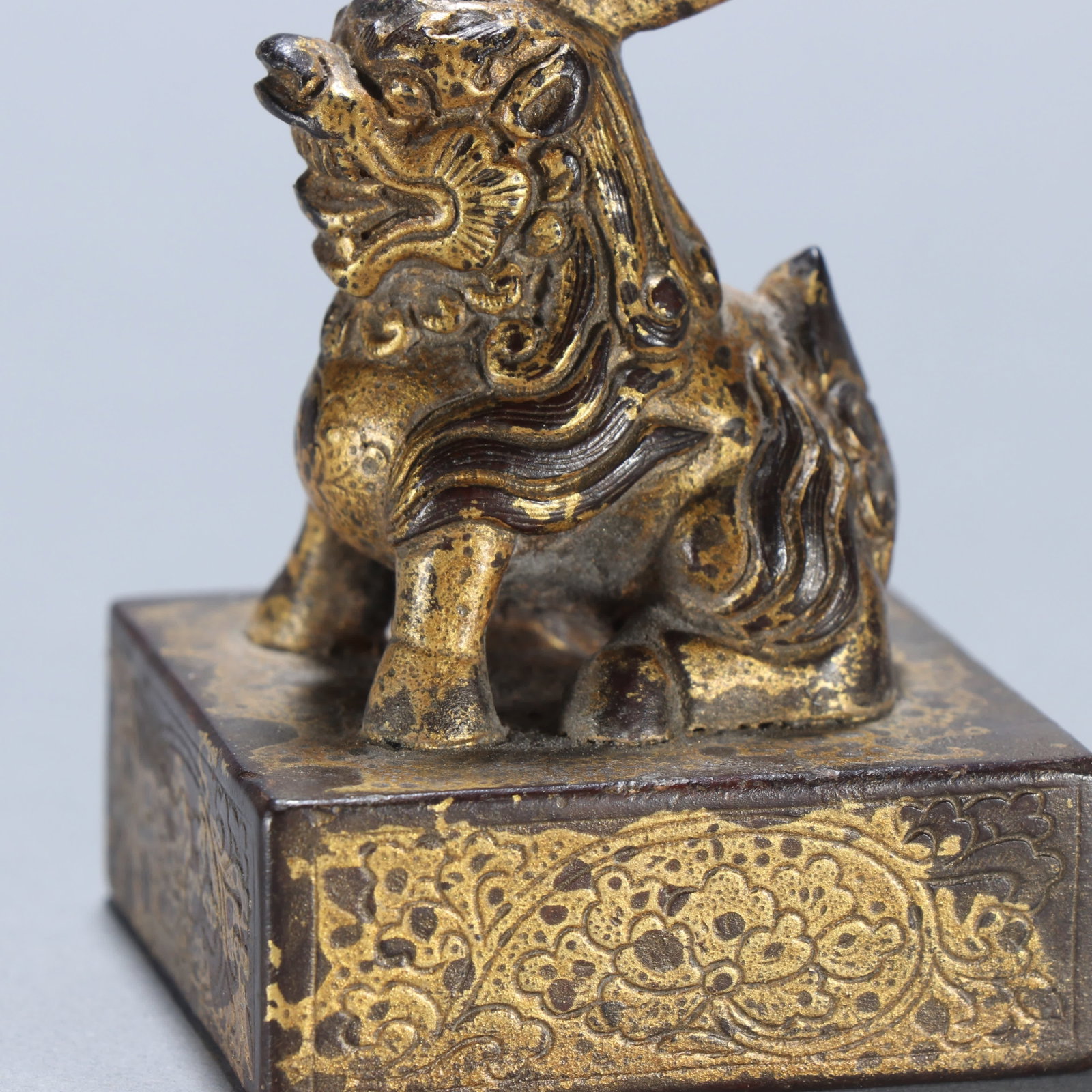 A copper gilt beast button seal - 2