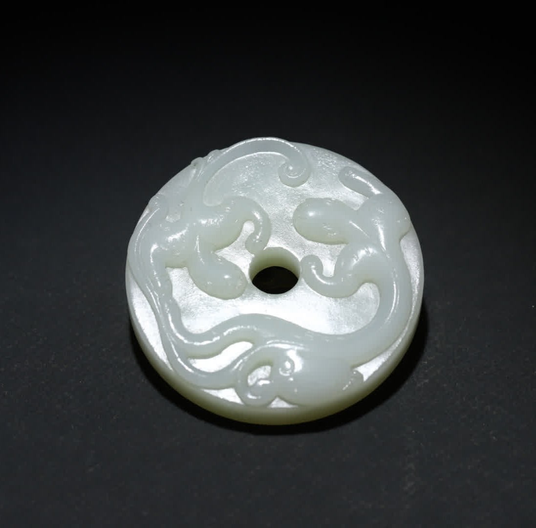 A Qing Dynasty Hetian jade double dragon pattern: Qing Dynasty Hetian jade double dragon pattern jade is warm and delicate, restrained in fat, and the color is clear and elegant. The front high relief technique carves the coiled state of the double