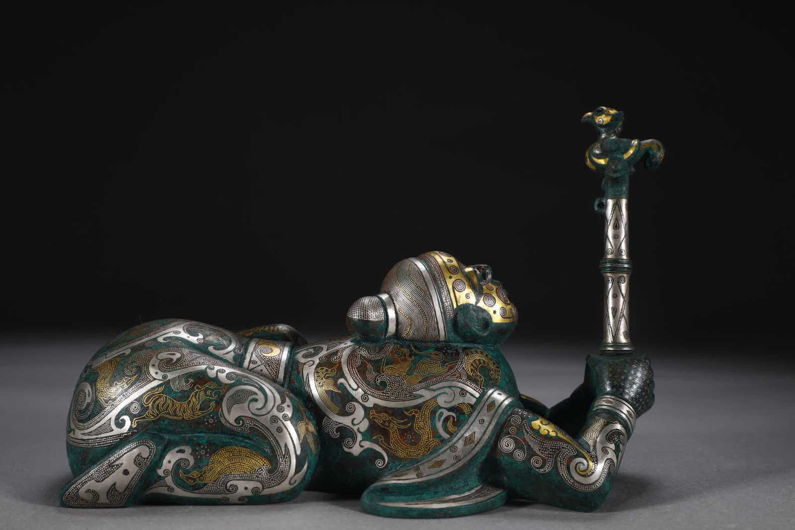 A piece of Spring and Autumn Warring States bronze Cuo gold and silver bird teasing man: Spring and Autumn Warring States Bronze Cuo Gold and Silver Bird Teasing Man [Detail] This vessel is made of bronze as a fetus, shaping a human figure in a prone posture, the character is smiling and 