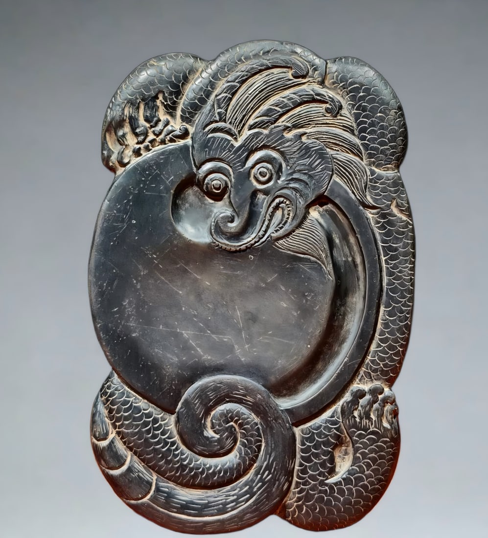 A dragon pattern end inkstone signed by Dong Gao: Dong Hao is carved into the shape of a banner dragon, and the inkstone surface is made into a perfect circle where the ink is received, like a coiled dragon holding a pearl, and the ink pool is at the