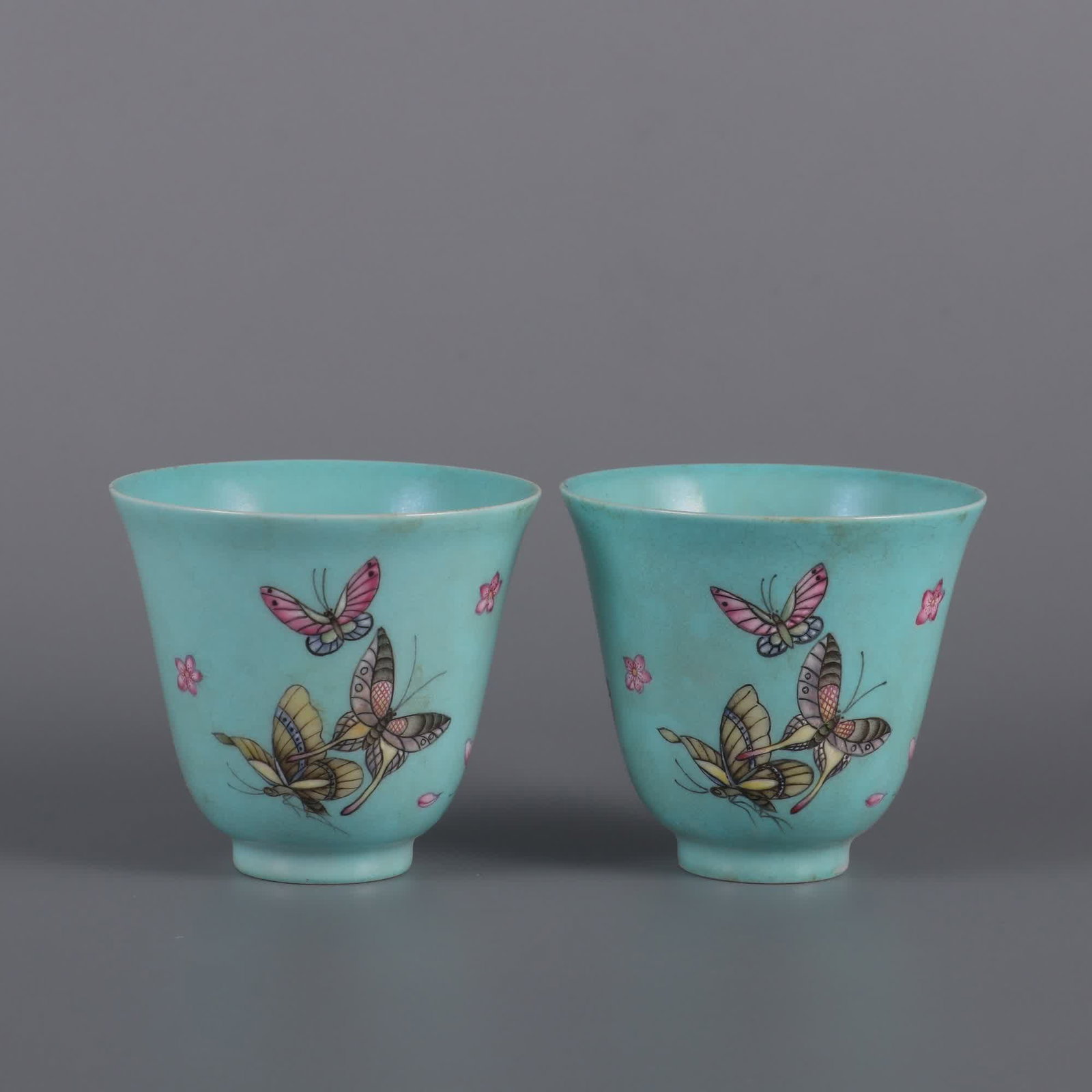 A pair of turquoise green enamel butterfly love pattern cups made in the Yongzheng era of the Qing: A pair of turquoise green enamel colorful butterfly love pattern cups made in the Yongzheng era of the Qing Dynasty SIZE: H:6cm MouthD:6.5cm (The Dimensions Of All Batches Are Manually Measured.If You