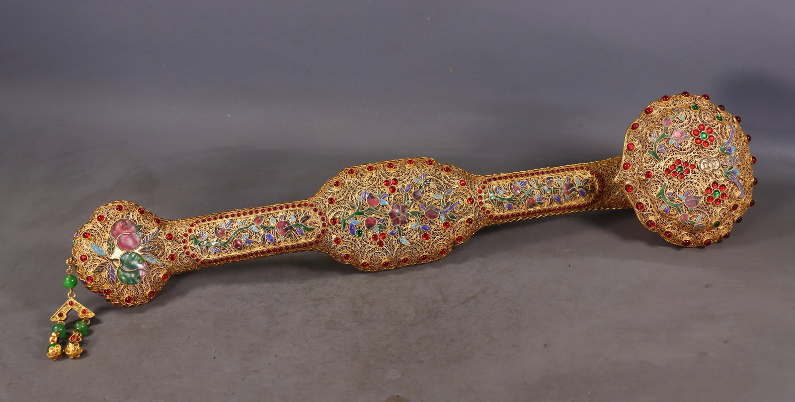 An Exquisite Gilt Bronze Inlaid Gems Flower Pattern Bats and Peach Pattern Ruyi: An Exquisite Gilt Bronze Inlaid Gems Flower Pattern Bats and Peach Pattern Ruyi Qing Dynasty, China Qianlong Four-character Mark Size:9cmx51cmx11.5cm Weight:800g (The Dimensions Of All Batches Are