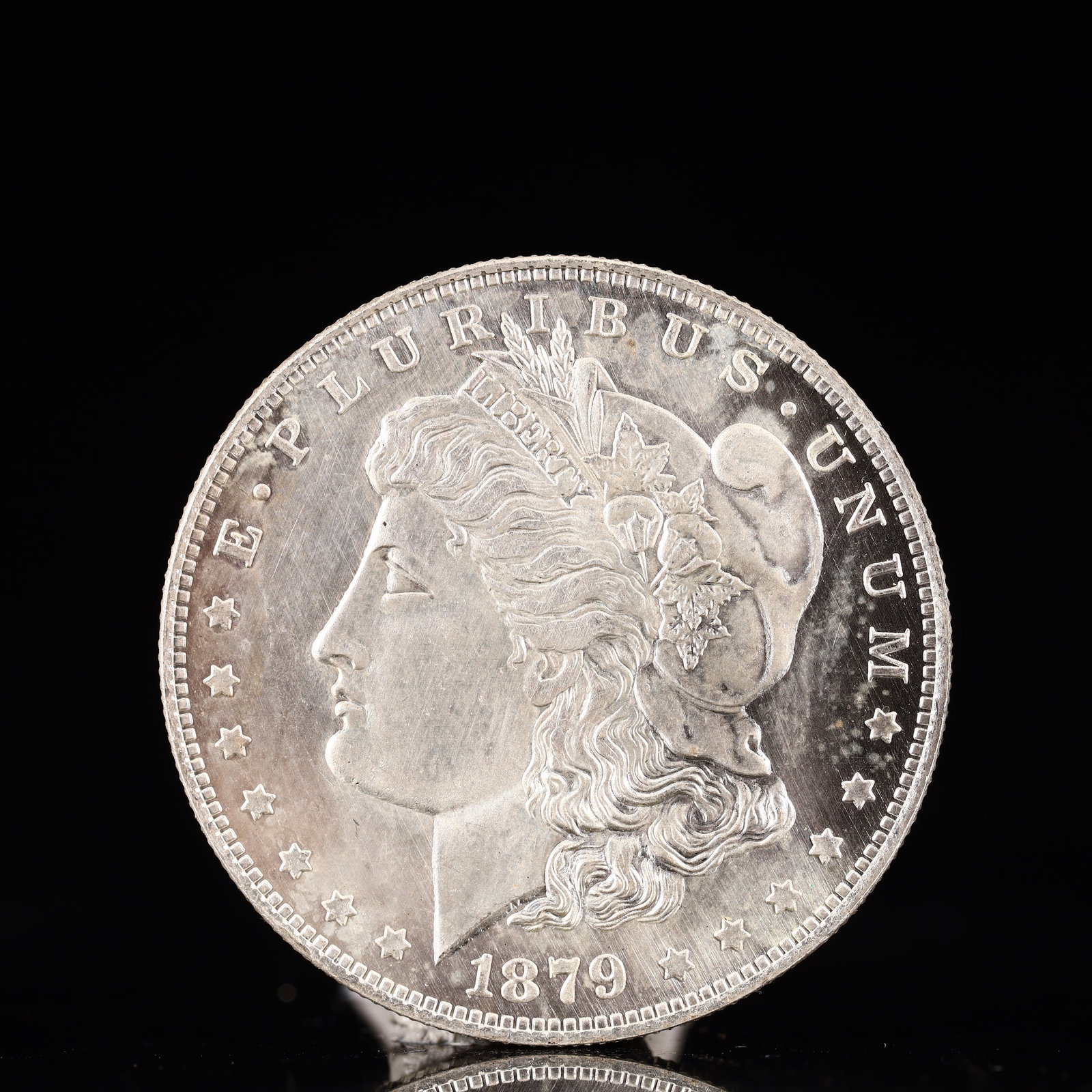 USA Morgan Dollar 1879 Coin: Obv: profile bust with date below and E PLURIBUS UNUM legend and stars around. Rev: eagle with In God we trust above within wreath with UNITED STATES OF AMERICA ONE DOLLAR legend. IN GOD WE TRUST /