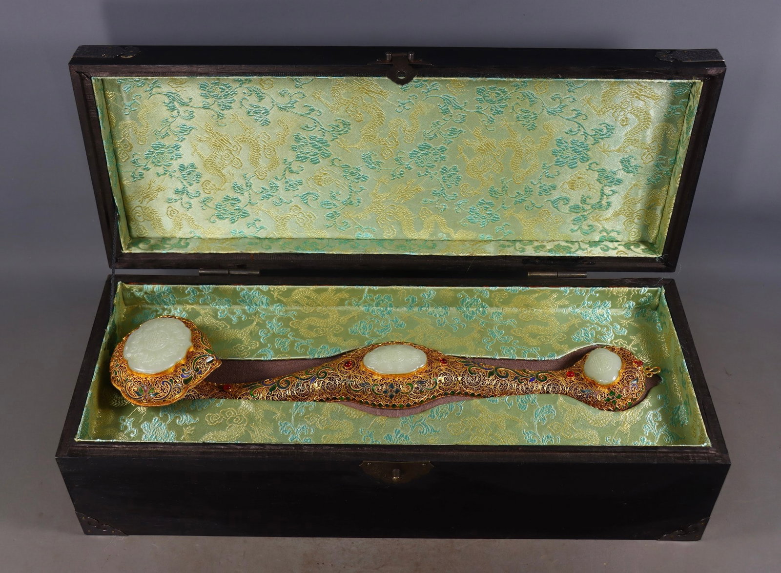 An Exquisite Gilt Bronze Inlaid White Jade Lotus Pattern Bats and Peach Pattern Ruyi: An Exquisite Gilt Bronze Inlaid White Jade Lotus Pattern Bats and Peach Pattern Ruyi Qing Dynasty, China Qianlong Four-character Mark Size:8cmx43cmx9.5cm Weight:750g (The Dimensions Of All Batches