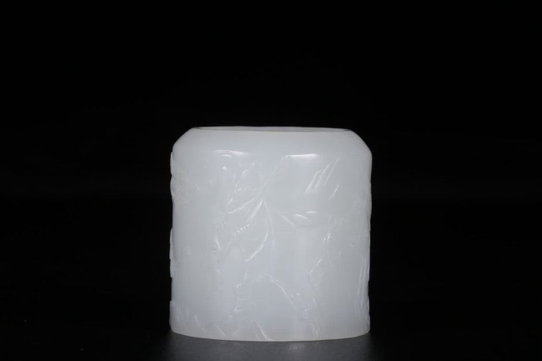 A Qing Dynasty Hetian white jade fisherman's 'Profit' thumb ring: Qing Dynasty Hetian White Jade Fisherman's Profit Thumb Ring. This thumb ring is cylindrical in shape and made from Hetian white jade, with a delicate, smooth texture and rich oiliness. The surface