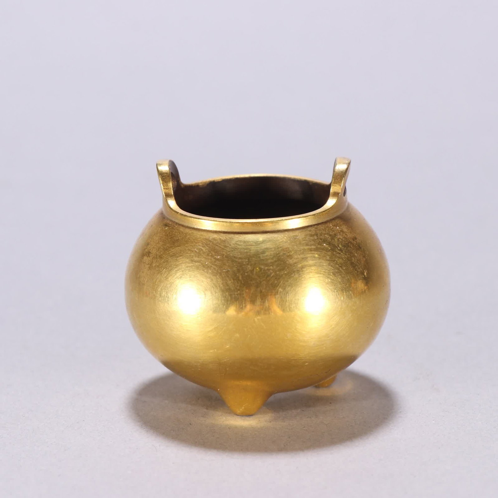 One Xuande mark bronze gilt three-legged incense burner: Xuande Mark: Bronze gilt three-legged incense burner SIZE: H:4.7cm W:5.1cm W:150.9g (The Dimensions Of All Batches Are Manually Measured.If You Need More Detailed Information, Please Contact Our