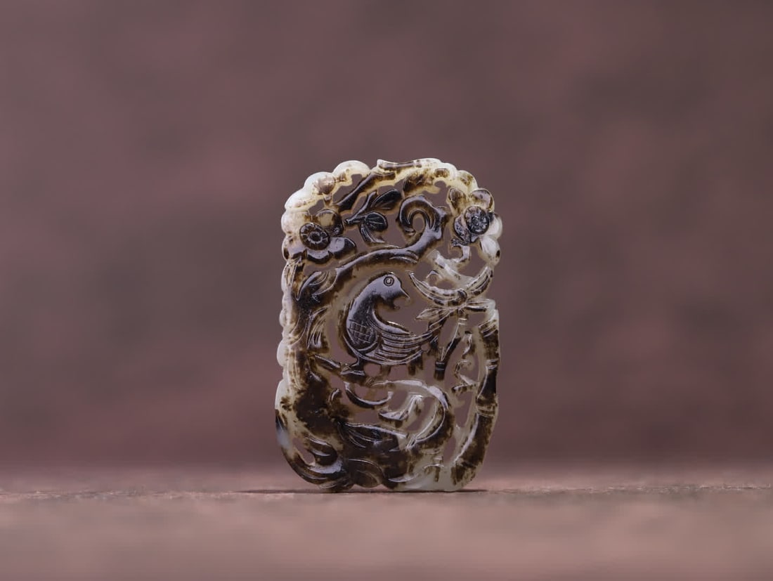 A Qing Dynasty Hetian jade seed piece with a 'joy on the eyebrow' open carving plaque: Qing Dynasty Hetian jade seed material 'Joy Brings Joy to the Brow' openwork plaque. The overall form is shaped like a plaque, carved using multi-layer openwork carving techniques. The jade is warm