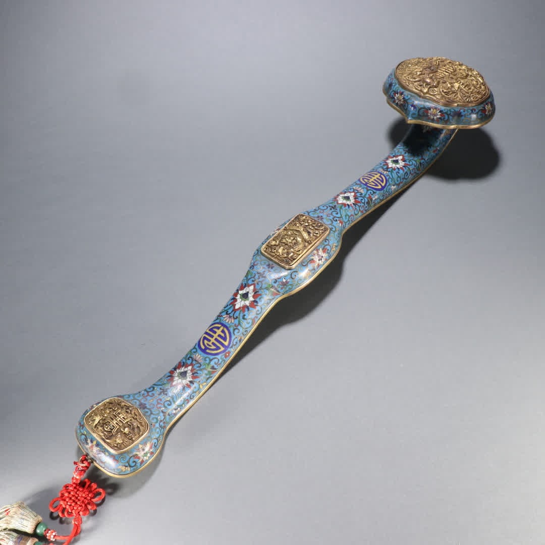 A Qing Dynasty gilt copper cloisonne "Five Blessings Longevity" Ruyi Treasure: Qing Dynasty gilt bronze cloisonne "Five Blessings Holding Longevity" Ruyi Bao SIZE: Specifications: L: 52cm W: 11.6cm W: 1047g (The Dimensions Of All Batches Are Manually Measured.If You Need More De