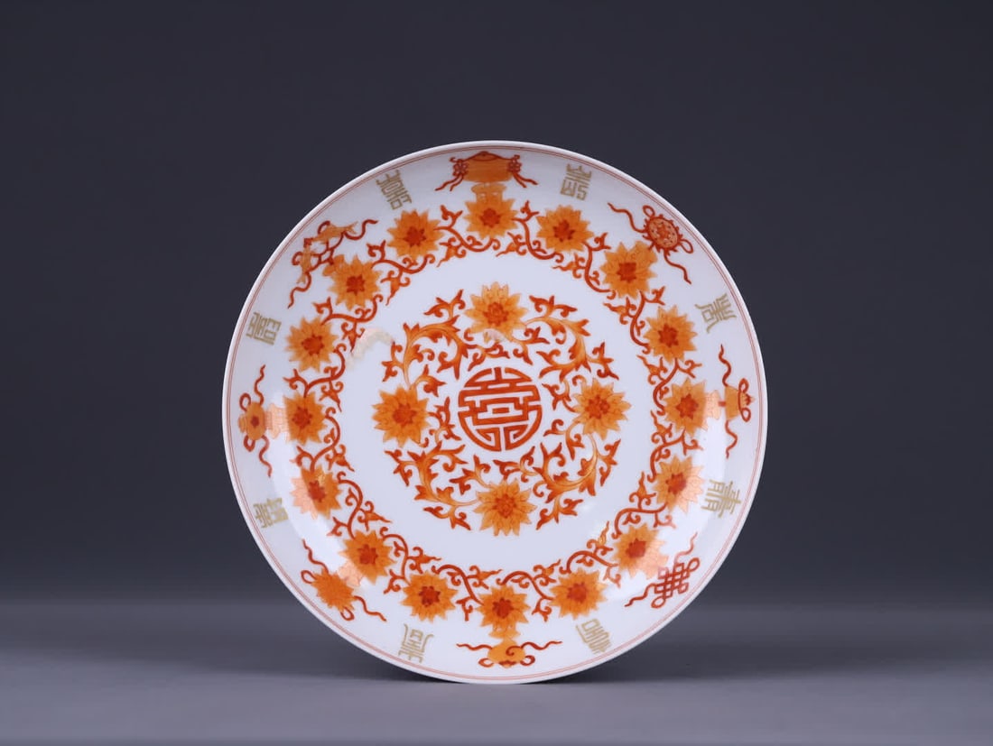A Qing dynasty Qianlong period plate with alum red and gilded fortune and longevity patterns: Qing Qianlong period alum red gilded fortune-longevity pattern plate is a classic plate with an open mouth, shallow belly, and ring foot. The shape is regular and full, with smooth and rounded lines, 