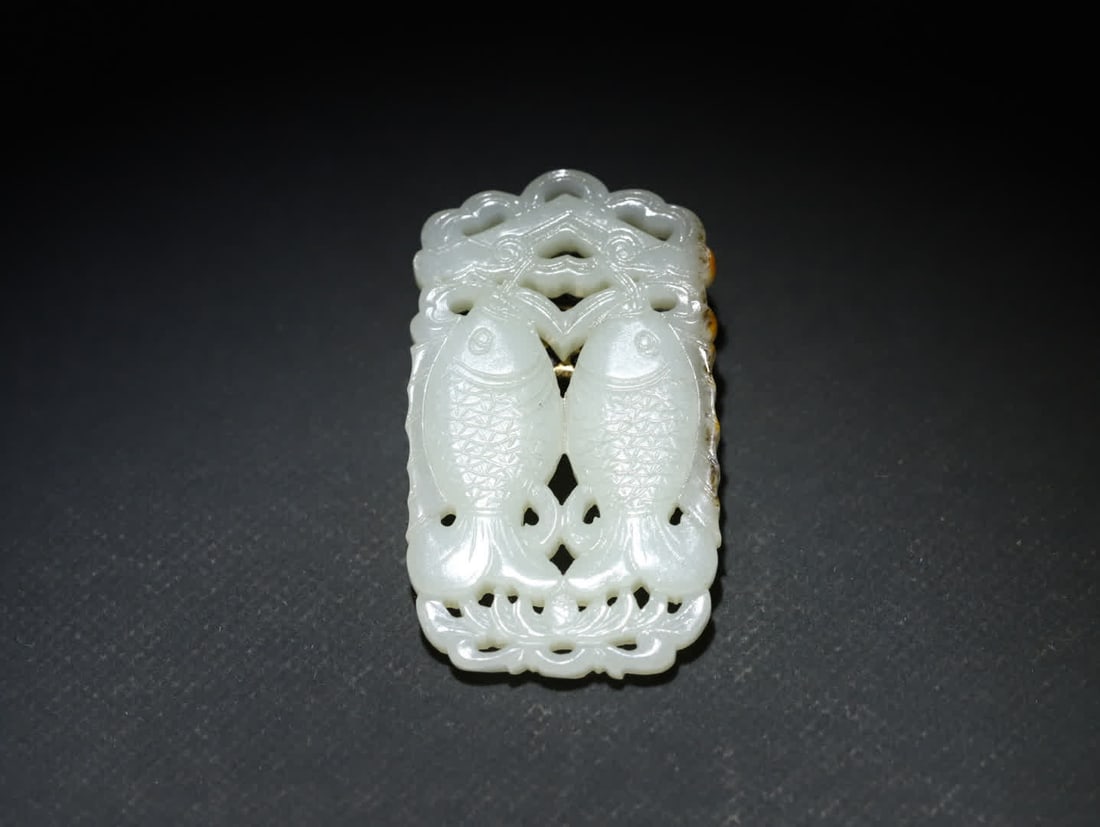 A Qing Dynasty old Hetian jade seed double fish pendant: Qing Dynasty Old Hetian Jade Seed Material Double Fish Pendant. The main material is Hetian jade seed jade, with a warm and delicate texture and a rich oily feel. Some parts retain the natural skin co