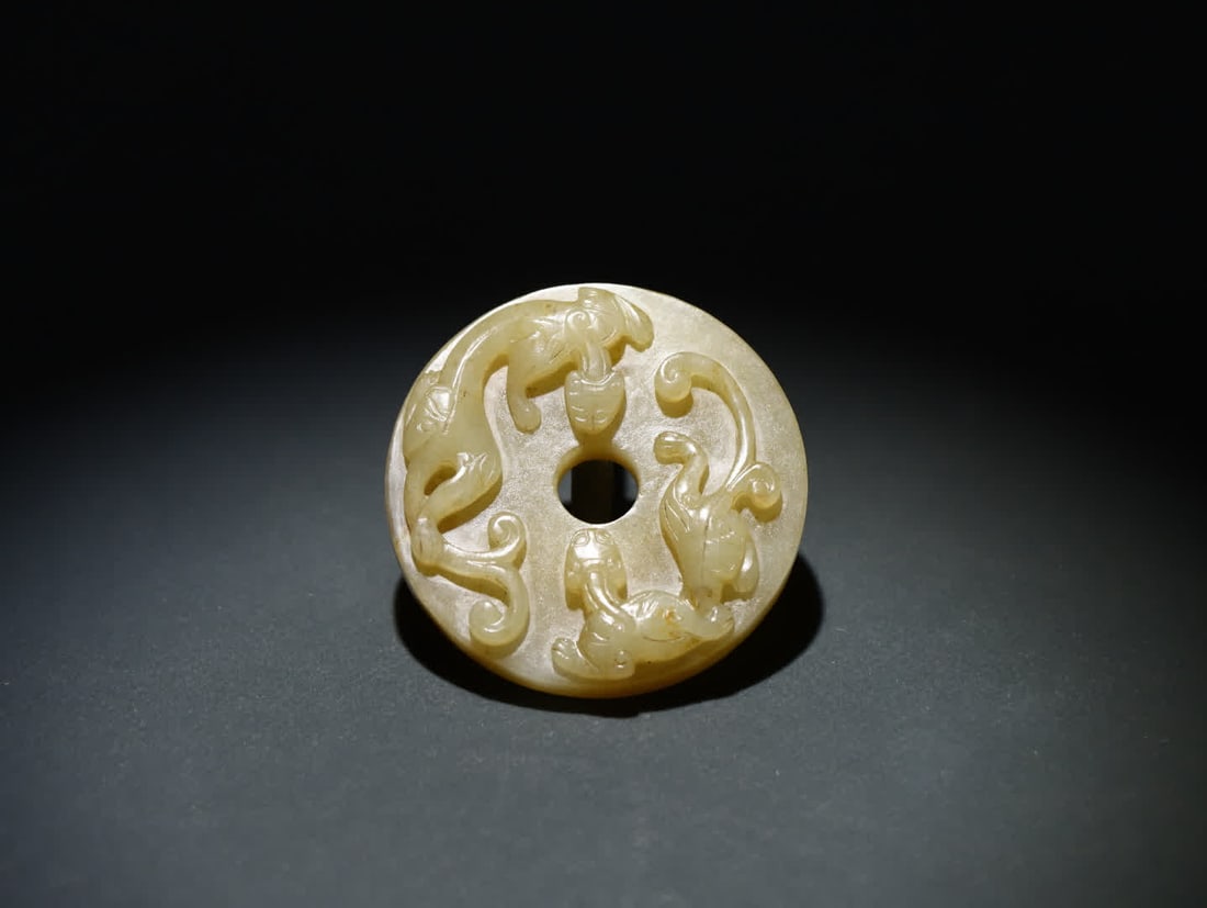 An old Hetian jade dragon bi: Old Hetian Jade Chi Dragon Bi: The jade is warm and delicate, with a restrained resinous feel. Its shape is the classic jade bi (Ping'an Kou) style, with a regular central round hole and a full,