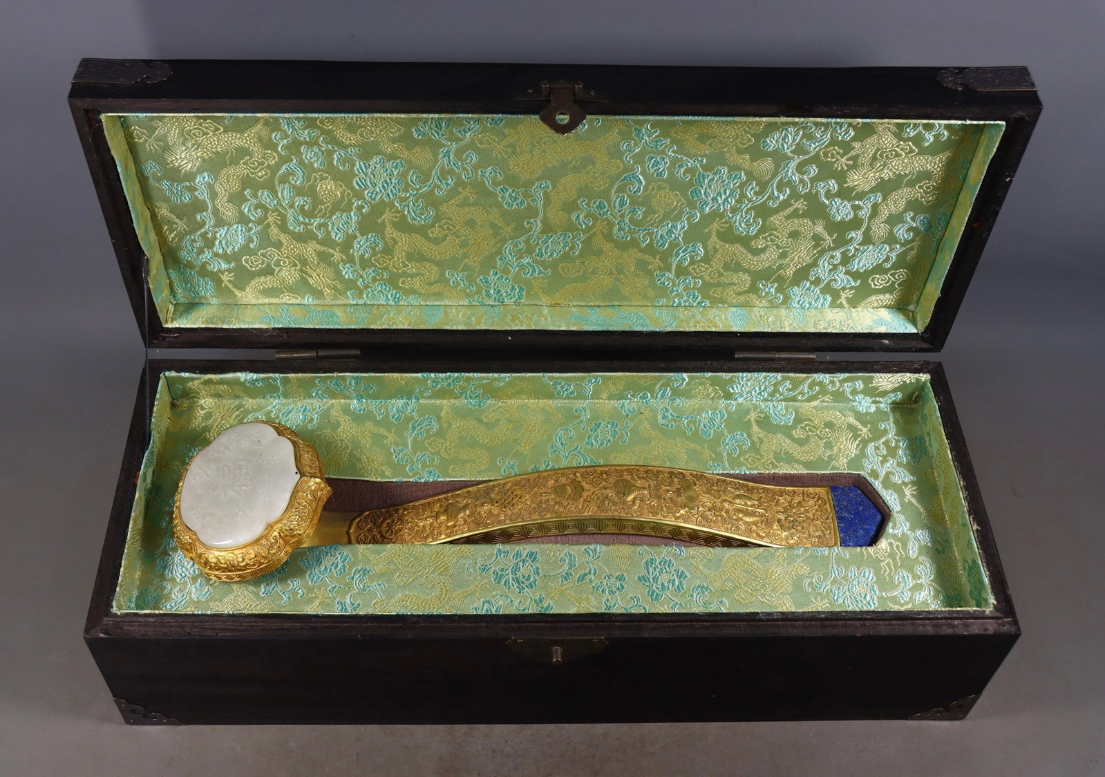 An Exquisite Gilt Bronze Inlaid White Jade Eight Treasures Pattern Ru yi: An Exquisite Gilt Bronze Inlaid White Jade Eight Treasures Pattern Ru yi Qing Dynasty, China Size: 8.5cmx40cmx10cm Weight:1300g (The Dimensions Of All Batches Are Manually Measured.If You Need More