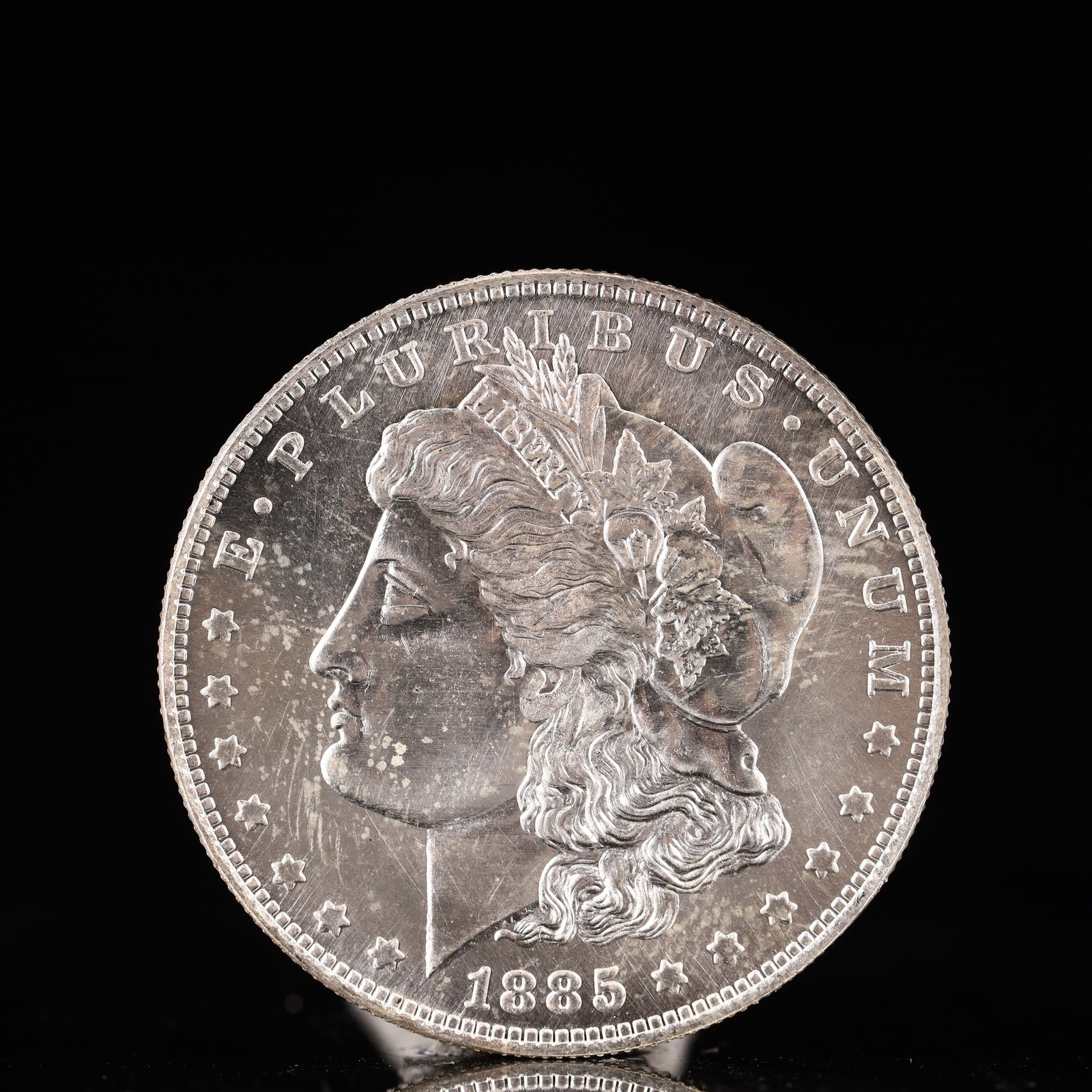 USA Morgan Dollar 1885 Coin: Obv: profile bust with date below and E PLURIBUS UNUM legend and stars around. Rev: eagle with In God we trust above within wreath with UNITED STATES OF AMERICA ONE DOLLAR legend. IN GOD WE TRUST /