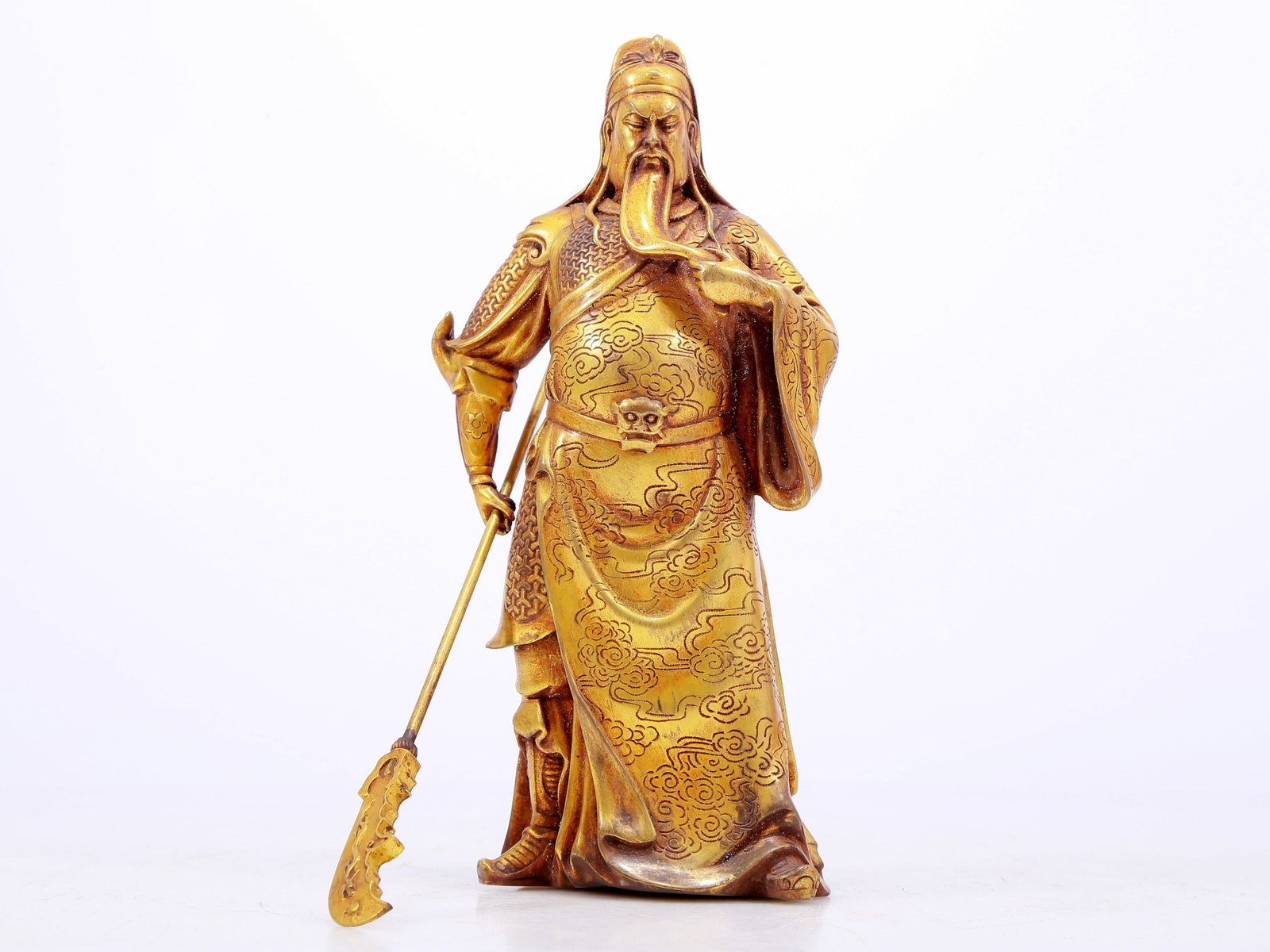 A Brilliant Gilt-Bronze Figure Of Guan Gong: A Brilliant Gilt-Bronze Figure Of Guan Gong. The bearded figure is stood with a serious expression, one hand holding a holy weapon, body rendered clad in an armor and a long, flowing robe with
