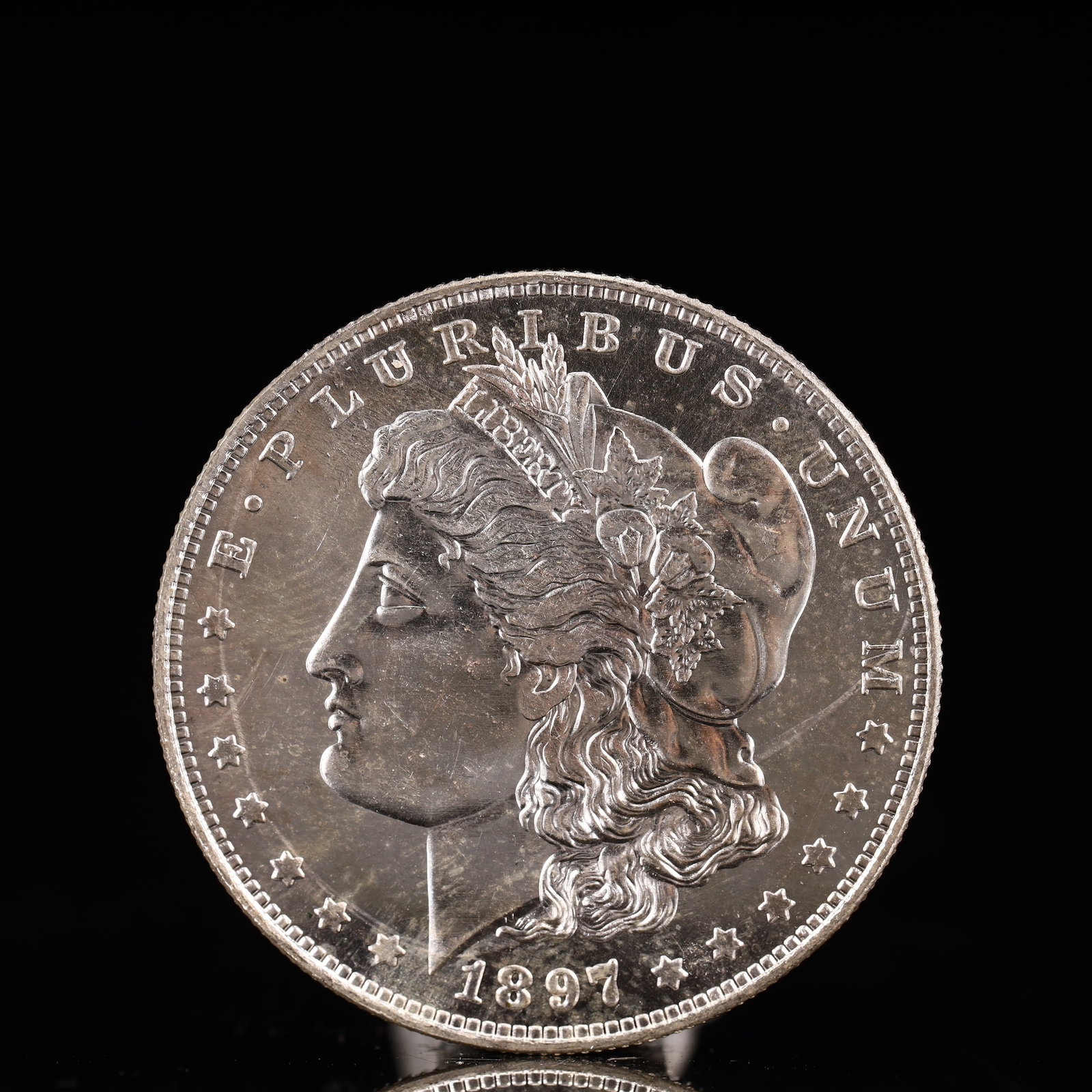 USA Morgan Dollar 1897 Coin: Obv: profile bust with date below and E PLURIBUS UNUM legend and stars around. Rev: eagle with In God we trust above within wreath with UNITED STATES OF AMERICA ONE DOLLAR legend. IN GOD WE TRUST / LI